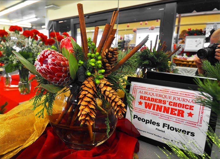 A lovely autumn arrangement stands next to a sign promoting Peoples as an Albuquerque Journal People's Choice Award Winner